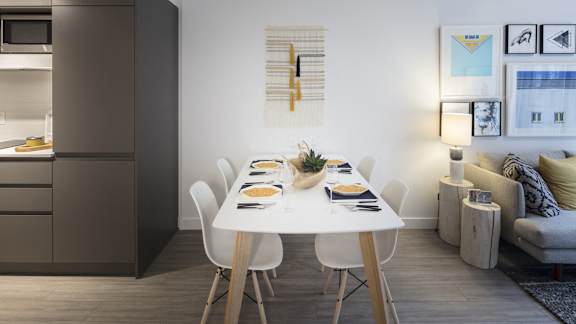 A modern dining room with a white table and chairs.