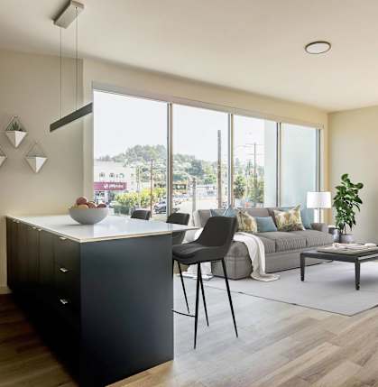 A modern kitchen with a black cabinet and a dining table with chairs.