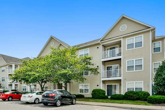 Car is parked in front of a two-story apartment building. at Potomac Station, Leesburg, 20176
