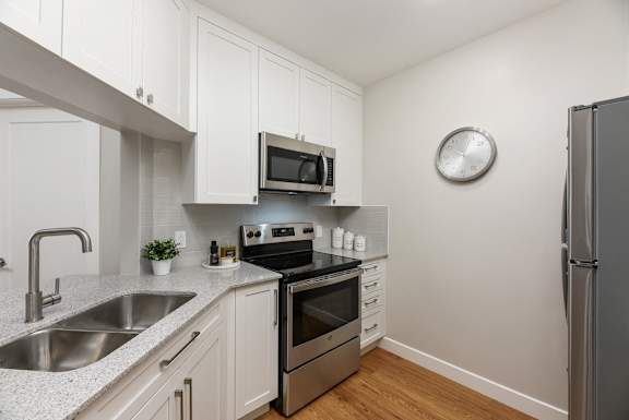 a kitchen with white cabinets and stainless steel appliances