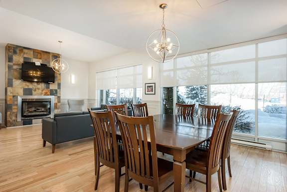 the dining room and living room with a large wooden table and chairs and a fireplace