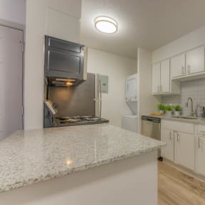 a kitchen with granite counter tops and a stainless steel refrigerator at Brightwaters Apartments, Little Rock, Arkansas
