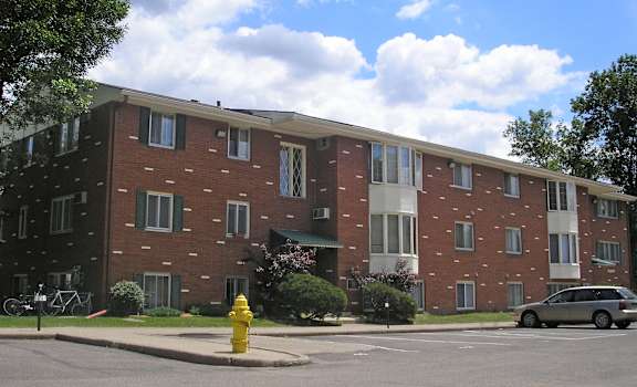 a red brick apartment building with a yellow fire hydrant in front of it