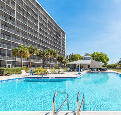 a large swimming pool with a hotel in the background