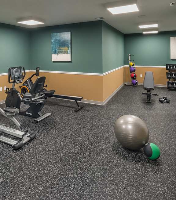 a gym with exercise equipment and a ball on the floorat Eden & Main 55+ Apartments, Southington , Connecticut