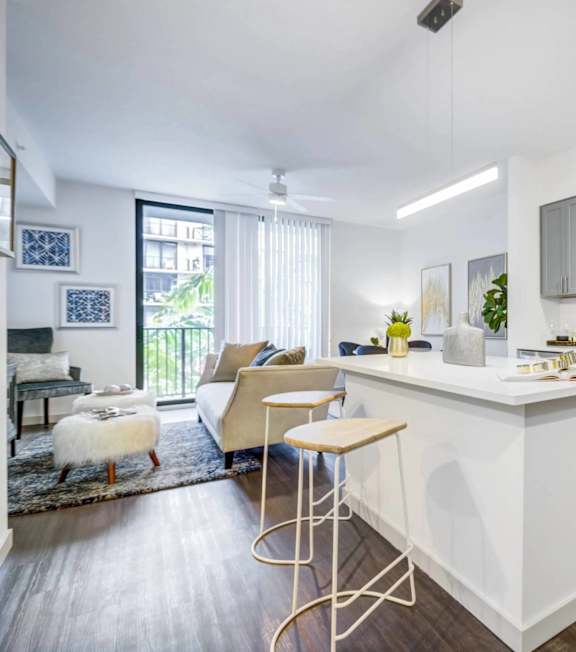 A modern kitchen with a white island and stainless steel appliances.
