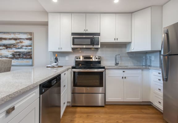 a kitchen with white cabinets and stainless steel appliances
