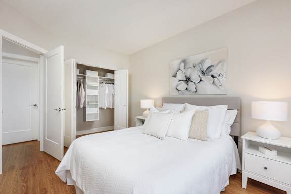 a bedroom with a large white bed and a closet