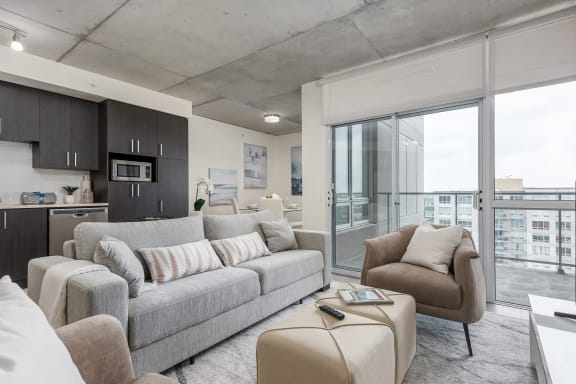 a living room with a couch and a chair in front of a window