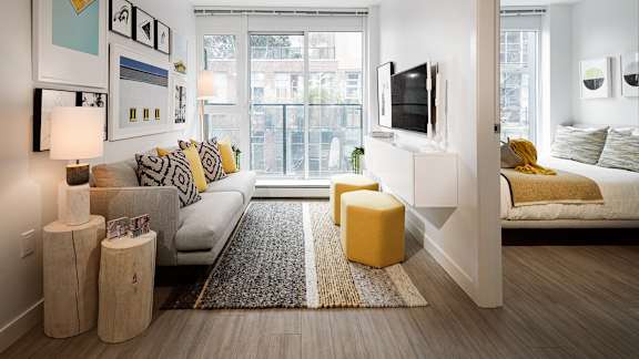 A modern living room with a large window and a white couch.