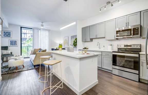 A modern kitchen with a white island and stainless steel appliances.