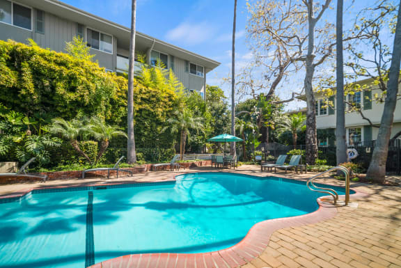 a swimming pool with a building in the background at Sunset Barrington Gardens, Los Angeles, CA, 90049