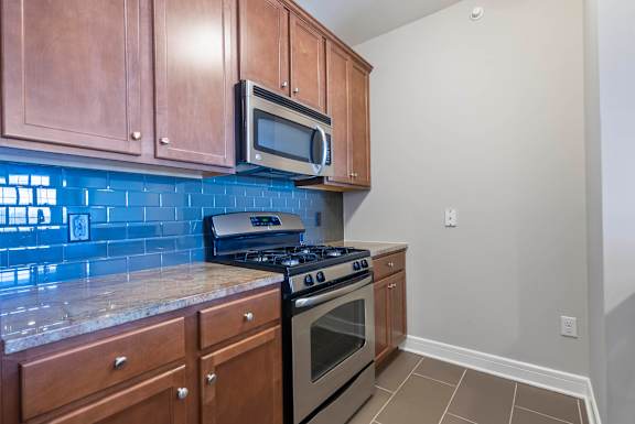 A kitchen with a stove, oven, microwave, and cabinets. at Pennsauken Golf Course Villas, PENNSAUKEN, NJ, 08109