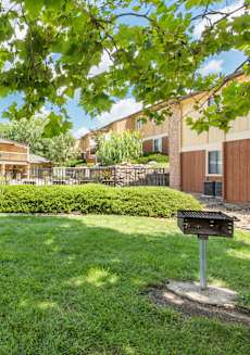 a yard with a grill and a building in the background at Lodge of Overland Park Apartments, Overland Park , 66212