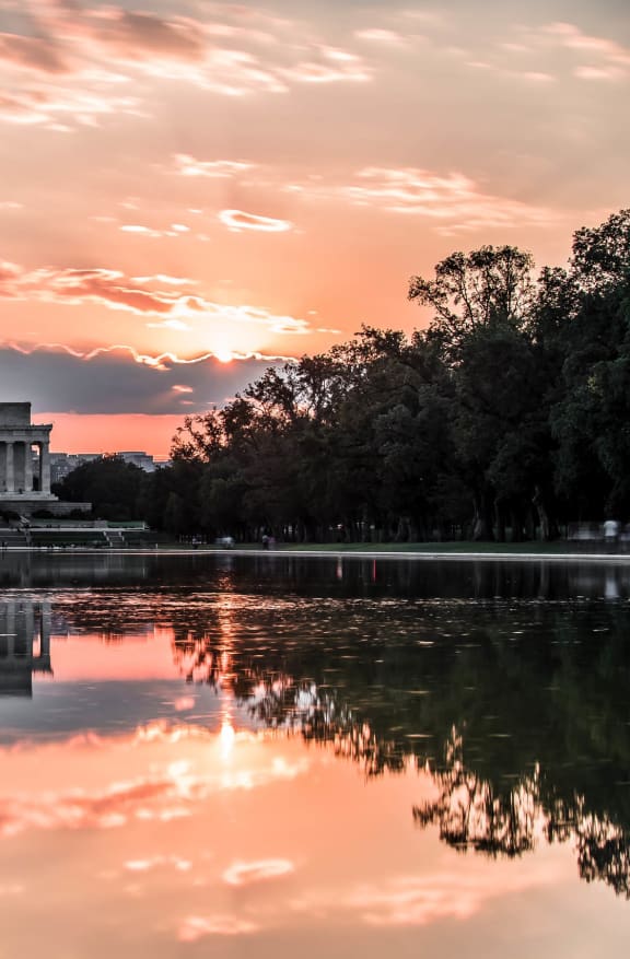 a sunset over the reflecting pool at the memorial
