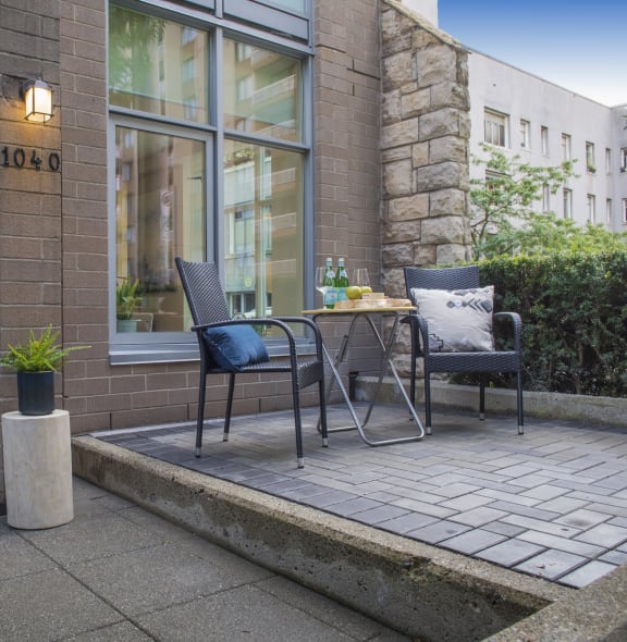 a patio with a table and chairs outside of a building