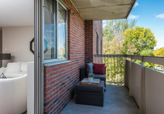a balcony with a couch and a table and a brick wall