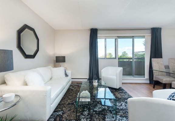 a living room with a white couch and a glass coffee table