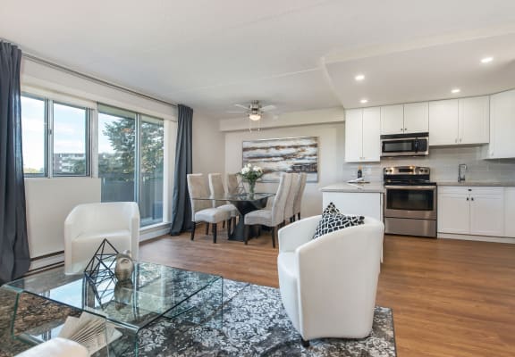 a living room with a dining room and a kitchen with a table and chairs
