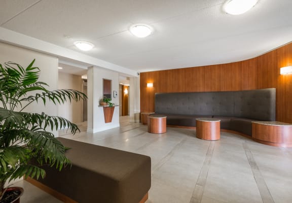 a lobby with a couch and tables and a plant