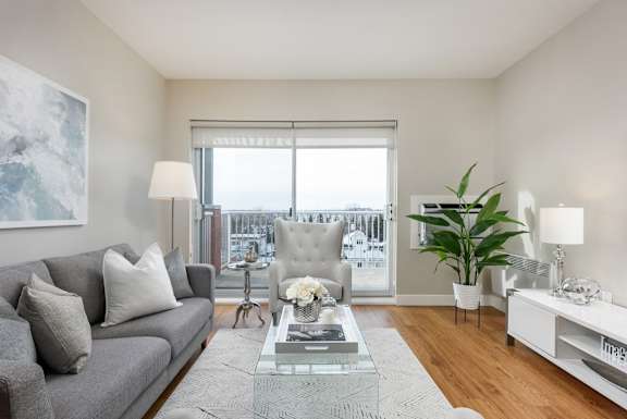 a living room with a couch and a coffee table and a large window
