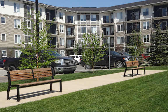 two park benches in front of an apartment building