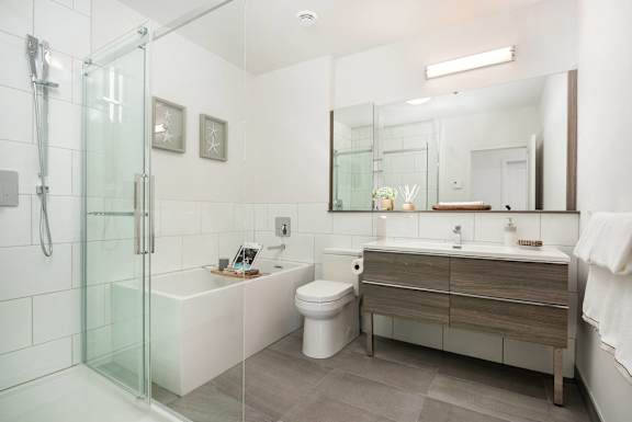 a bathroom with a toilet sink and shower and a mirror