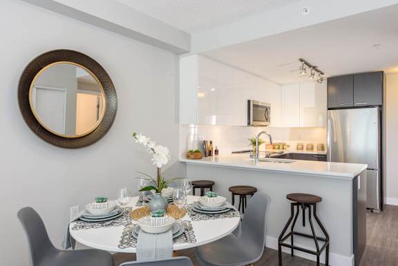 an open kitchen and dining area with a round table and chairs and a kitchen counter