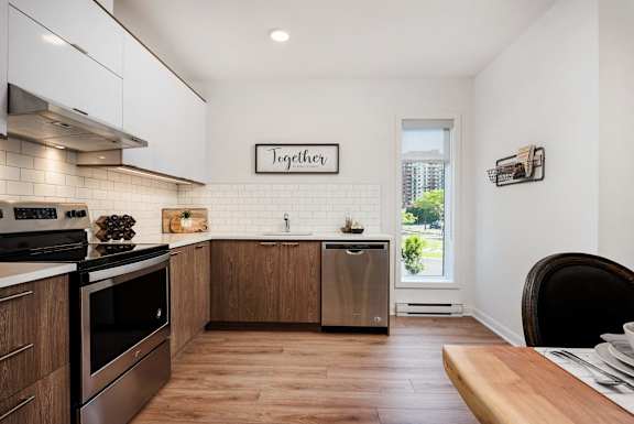 a kitchen with stainless steel appliances and a wooden table