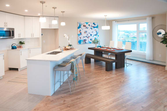 a kitchen with a large island and a dining table with chairs