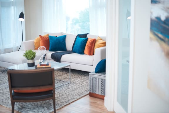 a living room with a white couch and colorful pillows