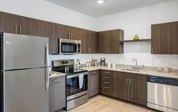 A modern kitchen with stainless steel appliances and wooden cabinets.