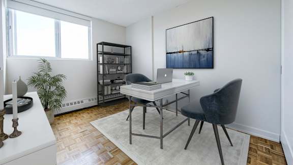 an open living room with a desk with a laptop and two chairs