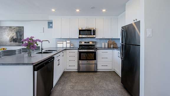 a large kitchen with white cabinets and stainless steel appliances