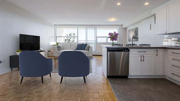 a living room with blue chairs and a kitchen with a sink and a television