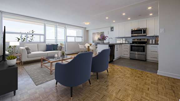 an open living room and kitchen with a couch and chairs
