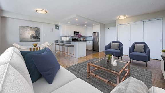 a living room with couches and chairs and a kitchen