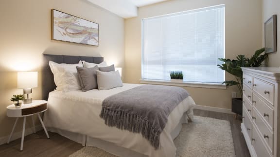 a bedroom with a bed and a large window