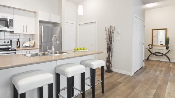 a kitchen with a bar and stools in a 555 sq ft apartment