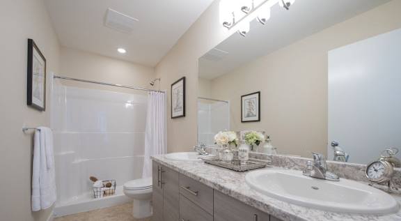A bathroom with a marble countertop and a white sink.