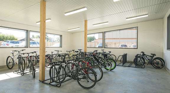 A bike rack with many bikes in a white room.