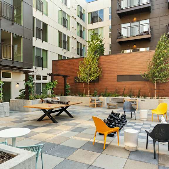A patio with a table and chairs is surrounded by buildings.