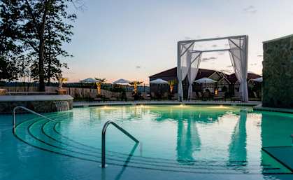 a swimming pool at sunset at the resort at governors crossing at The Villa at River Pointe, Maumelle, AR 72213