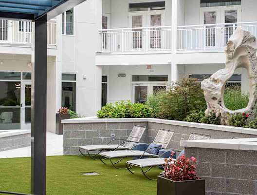A white building with a balcony and a sculpture of a bone.