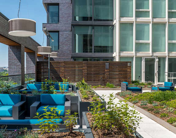 a courtyard with blue couches and plants in front of an apartment building