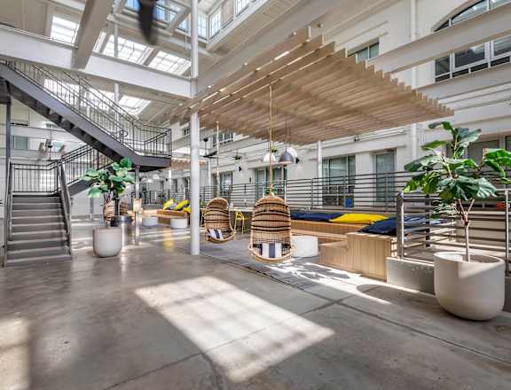 the lobby of an office building with stairs and plants at Highland Mill Lofts in North Carolina 28205