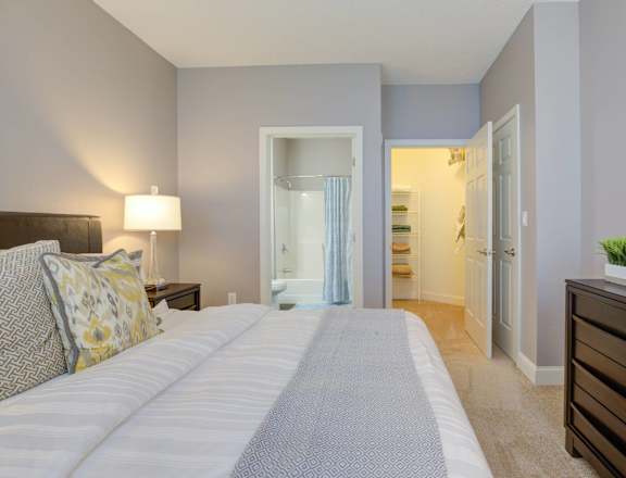 a bedroom with a large bed and a closet and a bathroom