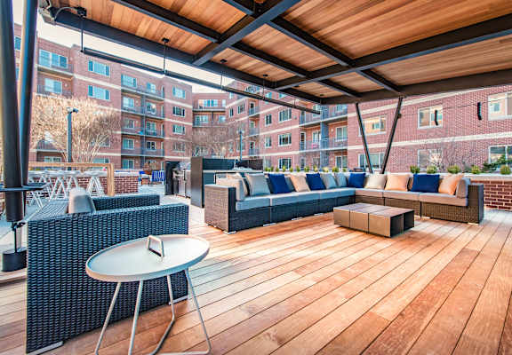 a rooftop patio with furniture and a table