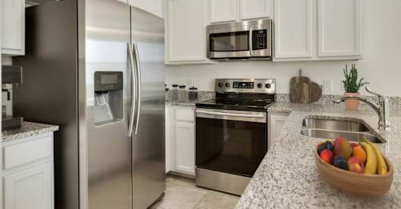 A kitchen with a stainless steel refrigerator, oven, and microwave.