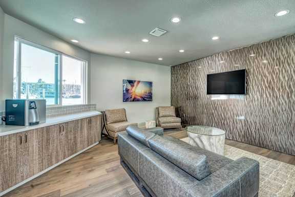 A modern living room with a grey sofa and a wooden cabinet.